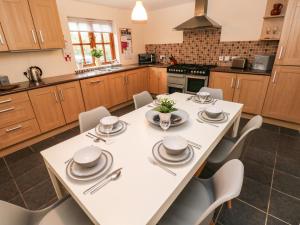 eine Küche mit einem weißen Tisch und Stühlen in der Unterkunft Ty Rhosyn in Haverfordwest