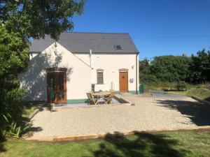 ein weißes Haus mit einem Picknicktisch davor in der Unterkunft Ty Rhosyn in Haverfordwest