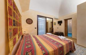 a bedroom with a bed with a colorful blanket at Angolo Arancio Bed & Breakfast in San Vito lo Capo