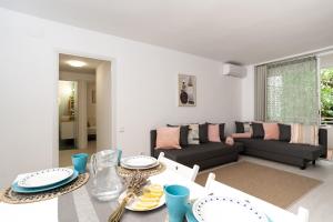 Apartment Bitacora FULLY RENOVATED 2023 في يوريت دي مار: غرفة معيشة مع طاولة وأريكة