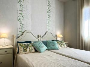 a bedroom with a white bed with pillows on it at Vivalidays Casa Ricardo in Sant Cebrià de Vallalta +41 photos