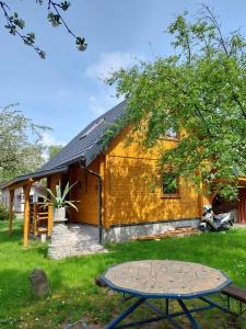 a yellow house with a picnic table in front of it at Domek Eva - Polanica Zdrój centrum in Polanica-Zdrój