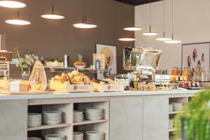 a kitchen with a counter with plates and food at acora Augsburg Living the City in Neusäß