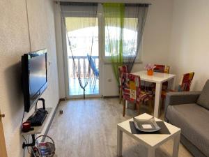 ein Wohnzimmer mit einer Couch, einem Fernseher und einem Tisch in der Unterkunft Apartment Maki with new Pool Nin in Vrsi