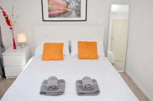 En eller flere senge i et værelse på 33SM Dreams Unlimited Serviced Accommodation- Staines - Heathrow