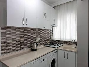 a kitchen with white cabinets and a sink and a stove at Asmin's House in Fatih in Istanbul