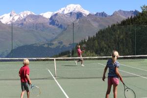 three people playing tennis on a tennis court at Les Arcs 1800 Ruitor in Arc 1800