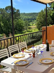 un tavolo bianco con piatti e bicchieri da vino sopra di Les Terrasses de Figanières a Figanières