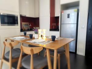 a kitchen with a wooden table with chairs and a refrigerator at Arcoris SOHO Mont Kiara in Kuala Lumpur