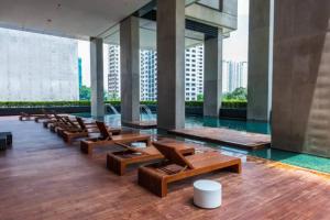 a lobby with chairs and a pool in a building at Arcoris SOHO Mont Kiara in Kuala Lumpur