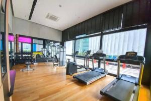 a gym with cardio equipment in a large room with wood floors at Arcoris SOHO Mont Kiara in Kuala Lumpur