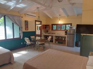 a kitchen and dining room with a table and chairs at Playa Negra Guesthouse in Cahuita