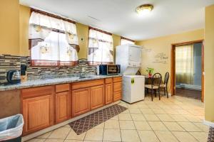 a kitchen with wooden cabinets and a white refrigerator at Cozy and Convenient West Orange Home - 16 Mi to NYC! in West Orange