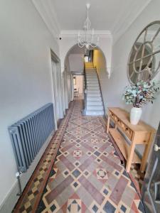 un pasillo con una escalera y una mesa con flores en Victorian Beach Villa, Hunstanton Norfolk, en Hunstanton
