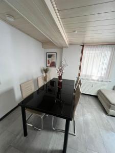 ein Esszimmer mit einem schwarzen Tisch und Stühlen in der Unterkunft Ferienhaus Möhrle 2 in Überlingen