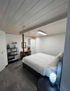 ein Schlafzimmer mit einem großen weißen Bett und einem Tisch in der Unterkunft Ferienhaus Möhrle 2 in Überlingen