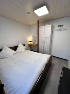 1 cama blanca grande en una habitación con luz en Ferienhaus Möhrle 2 en Überlingen