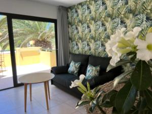 a living room with a couch and a table at Corralejo Atlantic Garden Andrew apartments Pool air conditioning in Corralejo