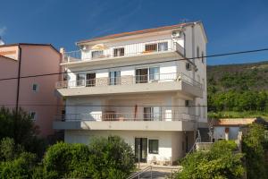 a white apartment building with a balcony at Apartments Adriatic in Selce