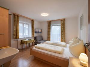 ein Hotelzimmer mit einem Bett und einem Waschbecken in der Unterkunft Haus Alton in Fieberbrunn