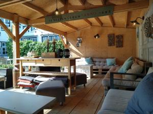 a patio with a table and couches in a room at Bed & Brasserie Het Kosthuys in Sint Maartensdijk