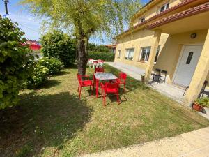 ein Tisch und Stühle im Hof eines Hauses in der Unterkunft Pensión Codesal in O Pedrouzo