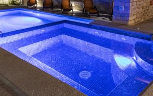 a large swimming pool with blue tiles on it at Luxurious Villa Istra Kamen in Pula