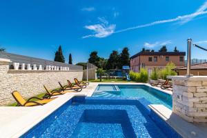 einen Pool mit Liegestühlen neben einem Gebäude in der Unterkunft Luxurious Villa Istra Kamen in Pula