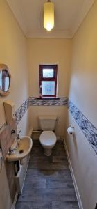 een badkamer met een toilet, een wastafel en een raam bij VH, 4 BR House, Upwell, Wisbech in Upwell