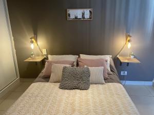 a bed with pillows on it in a bedroom at Andes Apartments Bandera in Mendoza