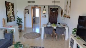 een woonkamer met een tafel en stoelen in een kamer bij Sunny holiday Apartment Miraflores in Sitio de Calahonda