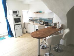 a kitchen with a wooden table and white appliances at Les insolites de Champeix 2 in Champeix