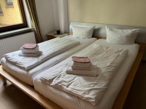a bedroom with two beds with white sheets and towels at Berg I 