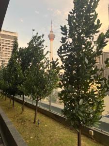 吉隆坡的住宿－Anggun KL Malaysia，一座有电视塔的建筑顶部的一排树木