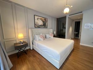 1 dormitorio con cama blanca y almohadas rosas en Anggun KL Malaysia, en Kuala Lumpur