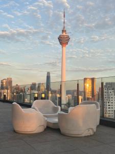 a rooftop with chairs and a view of the space needle at Anggun KL Malaysia in Kuala Lumpur