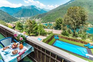 a view from the balcony of a house with a table with food and a pool at Le Terrazze sul Lago - Ledro House in Pieve Di Ledro