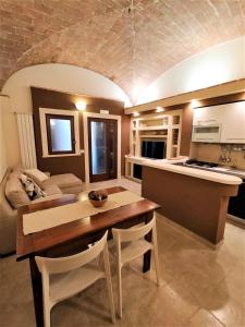 a kitchen and living room with a wooden table and chairs at Vittoria House in LʼAquila