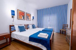 una camera con un letto con una coperta blu e bianca di Hotel Verde Pinho Bed&Breakfast a São Pedro de Muel