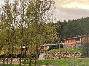 a house with a stone wall next to a road at Casa en la Molina in La Molina