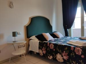 a bedroom with a bed with a green headboard at Lillananna Reload in Porto SantʼElpidio