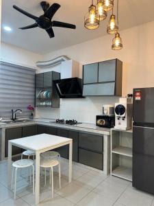 a kitchen with a table and a ceiling fan at The Amore Homestay in Muar