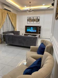 Sala de estar con 2 sofás y TV en The Amore Homestay en Muar