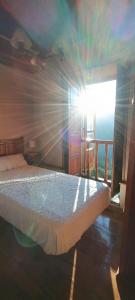 ein Schlafzimmer mit einem Bett, in dem die Sonne durch ein Fenster scheint in der Unterkunft Apartamentos Rurales San Esteban de los Buitres - Illano 
