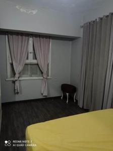 een kamer met een raam met gordijnen en een stoel bij شقة للايجار المفروش بسبورتنج in Alexandrië