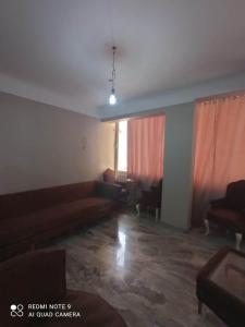 een lege woonkamer met een bank en een stoel bij شقة للايجار المفروش بسبورتنج in Alexandrië