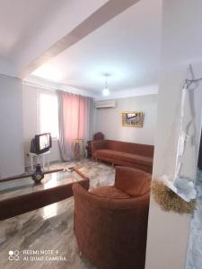 een woonkamer met een bank en een stoel bij شقة للايجار المفروش بسبورتنج in Alexandrië