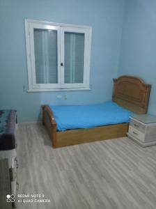 een slaapkamer met een bed en een raam bij شقة للايجار المفروش بسبورتنج in Alexandrië