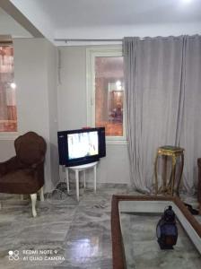 een woonkamer met een televisie en een bank bij شقة للايجار المفروش بسبورتنج in Alexandrië