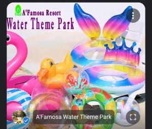 a rainbow resort water theme park with a flamingos and other toys at Rosnah Homestay in Kampong Ayer Resam